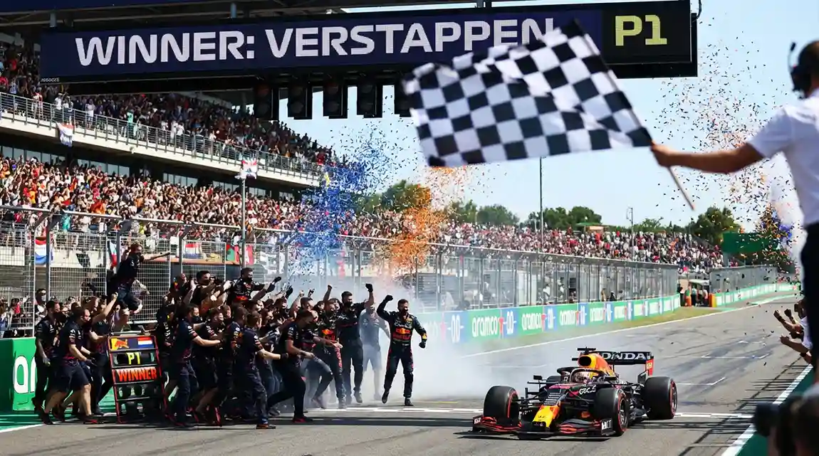 Formule 1-auto passeert de finishlijn als winnaar met juichend team