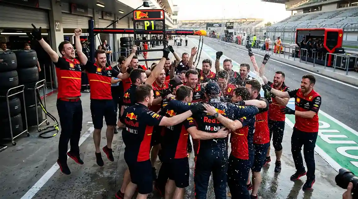 Formule 1-team viert een overwinning in de pitstraat met juichende monteurs