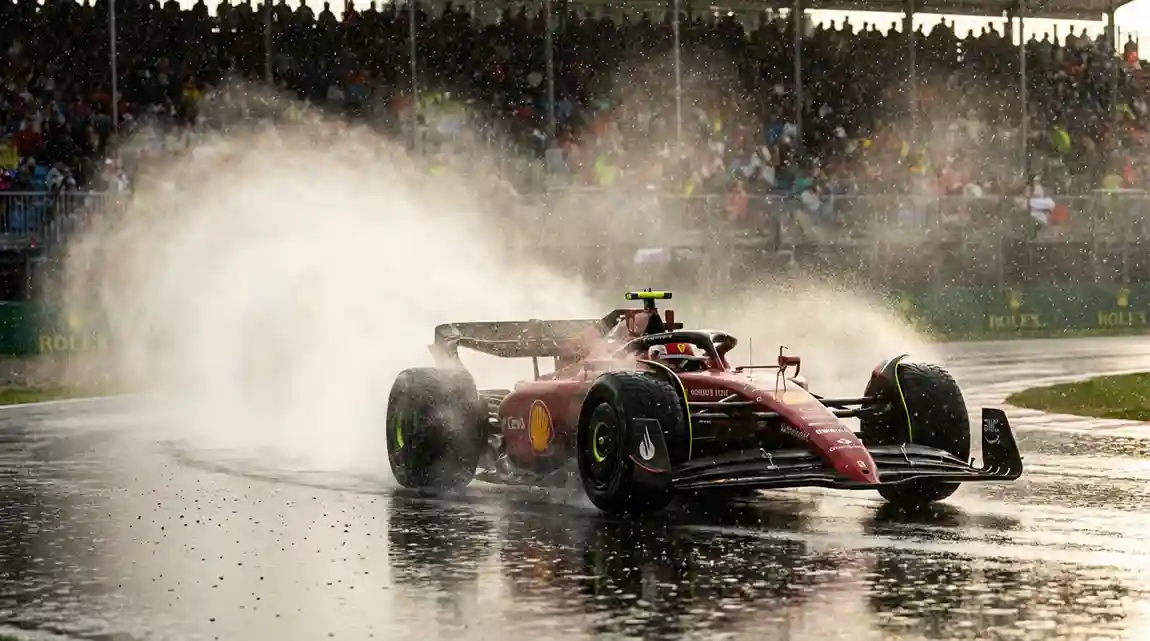 Formule 1-auto rijdt op een nat circuit met opspattend water