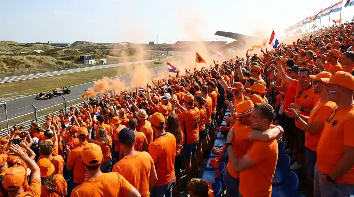 Enthousiaste Nederlandse F1-fans in oranje kleding juichen op de tribunes
